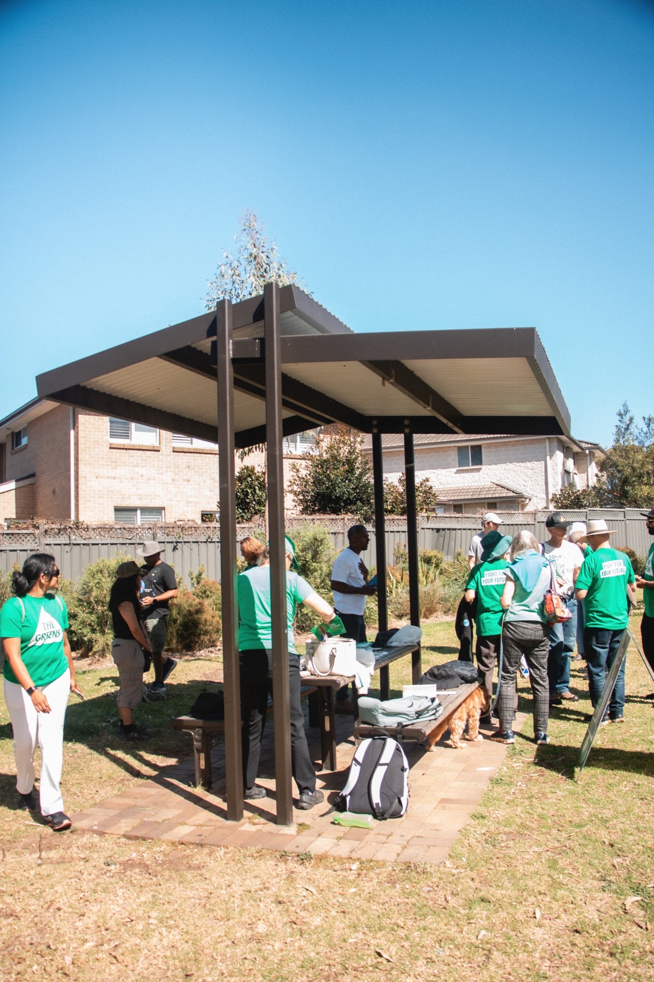 Community gathering with Greens volunteers under a park pavilion